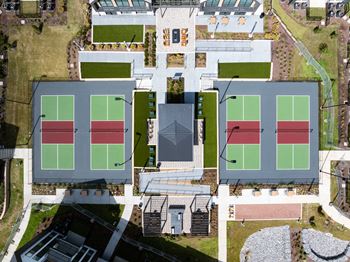 Stadium-style multi-court pickleball facility with tiered seating, wet bar, firepits, and tvs